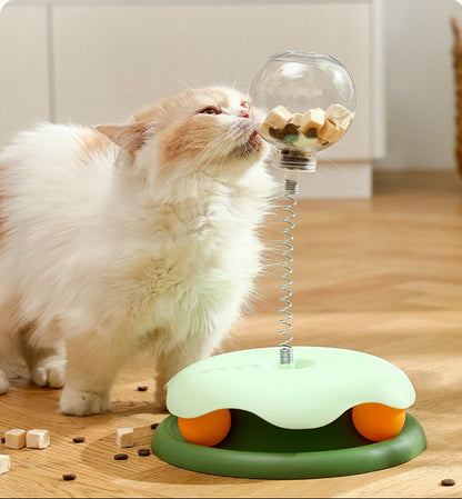 Cat playing with a transparent treat leakage ball toy on a wooden floor.