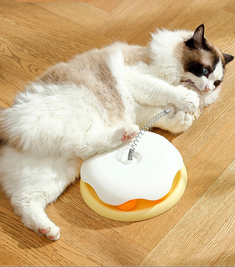 Cat playing with a toy on a wooden floor, with text about product features.