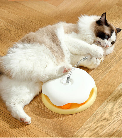 Cat playing with a toy on a wooden floor, with text about product features.