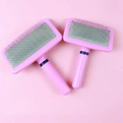 Two pink pet grooming brushes with  light green pads on a pink background