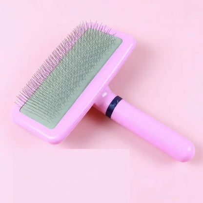 Pink pet grooming brush with green surface on a pink background